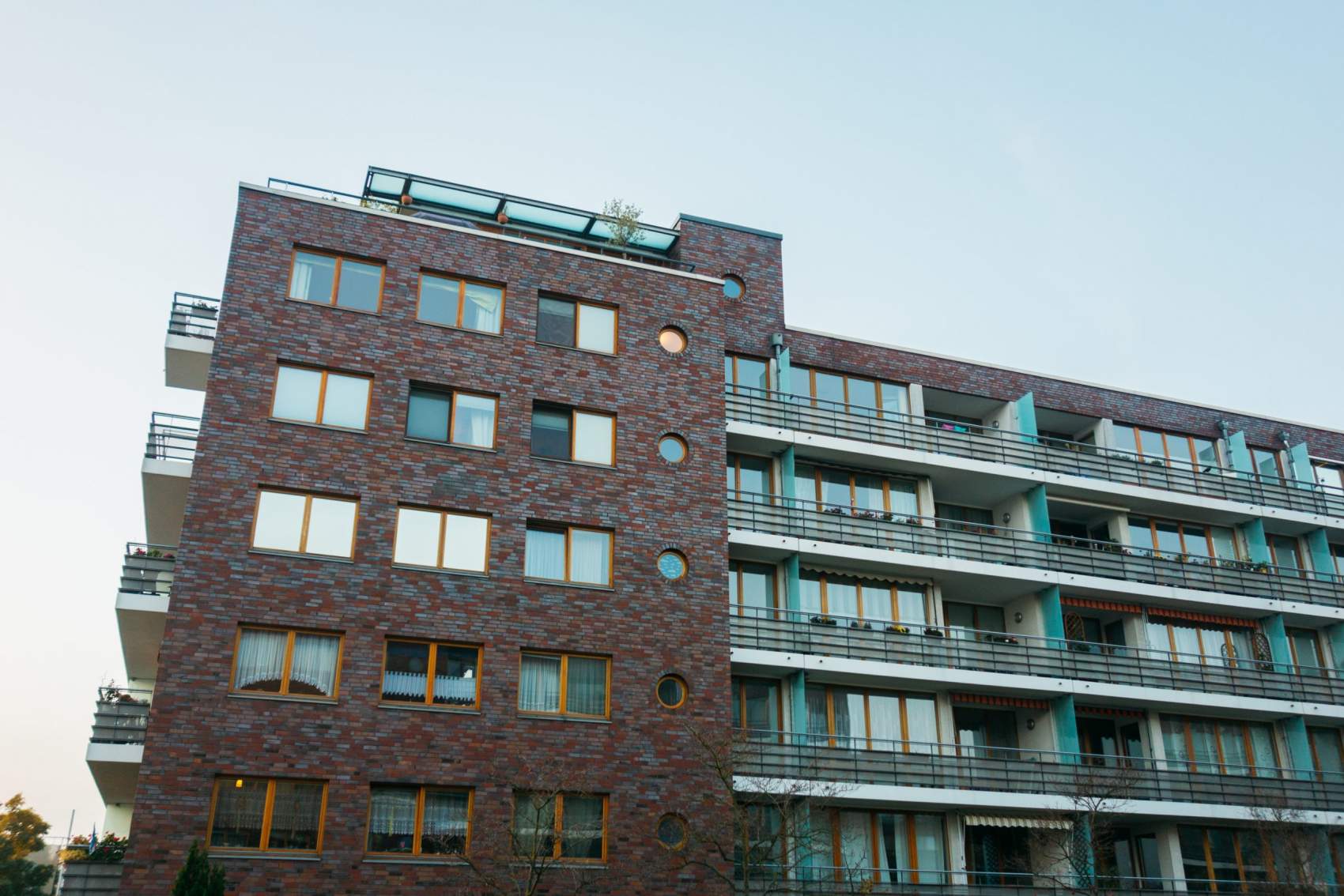 brick apartment house with steel balcony on a cloudy day