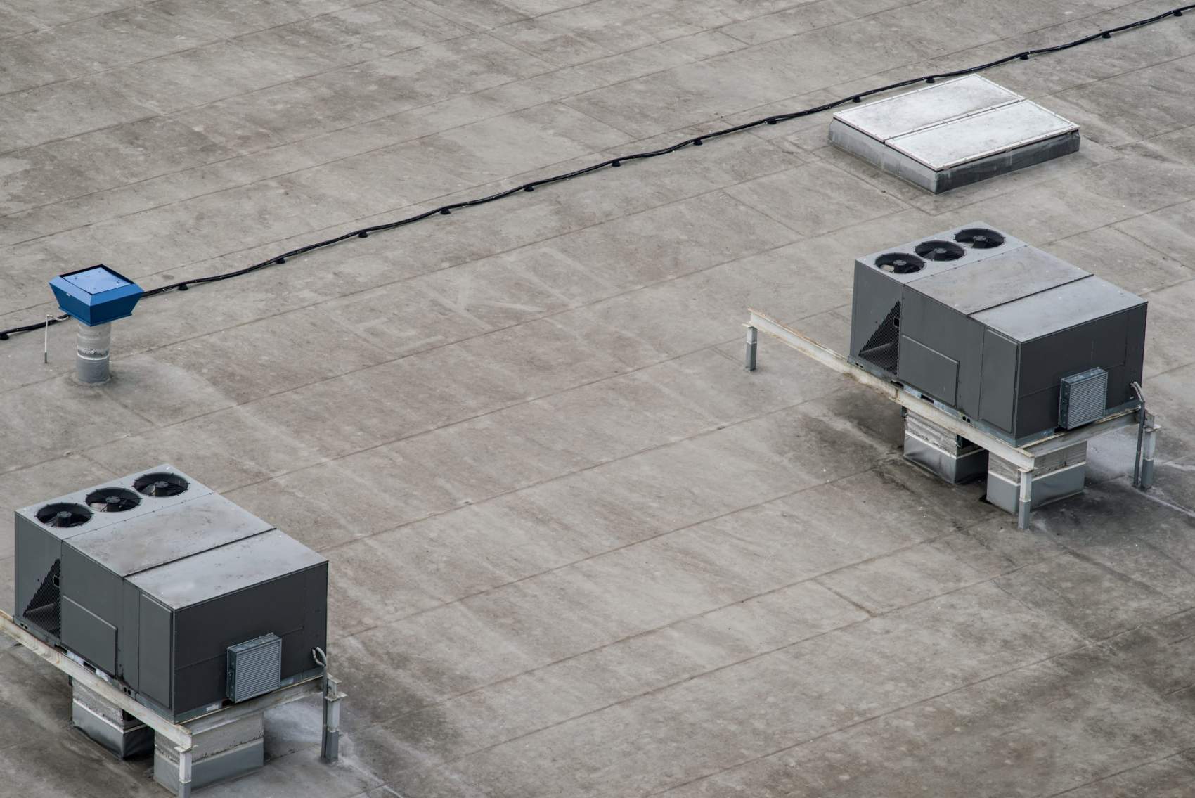 The external units of the commercial air conditioning and ventilation systems are installed on the roof of an industrial building.