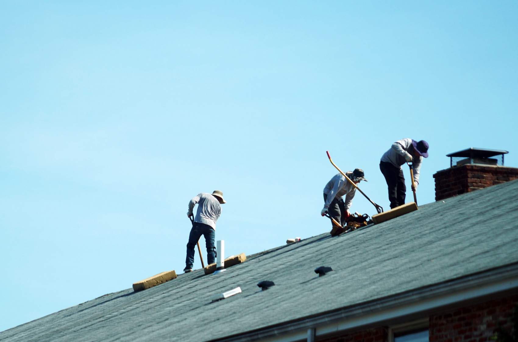 a group of worker repairing the apartment roof