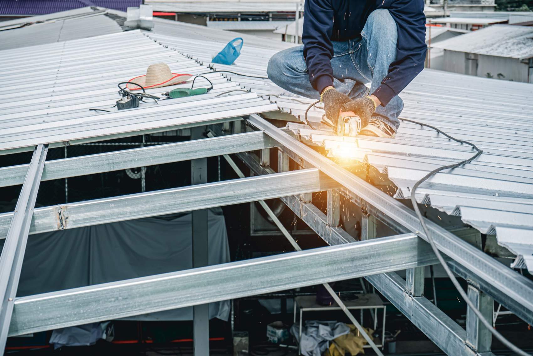 Thai Construction Worker Installing Metal Sheet On Warehouse Roo