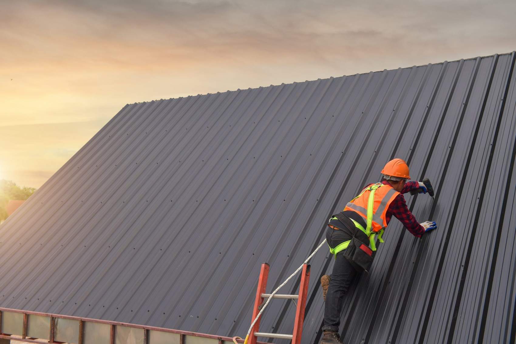 Roofer Construction worker install new roof,Roofing tools,Electric drill used on new roofs with Metal Sheet.