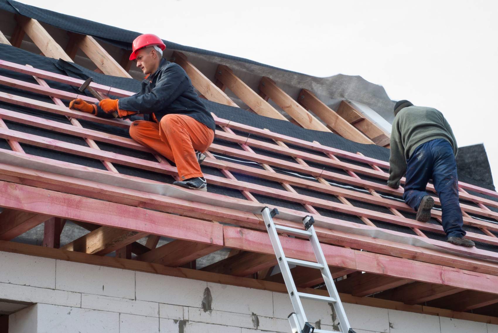 Worker installs bearing laths on the truss system
